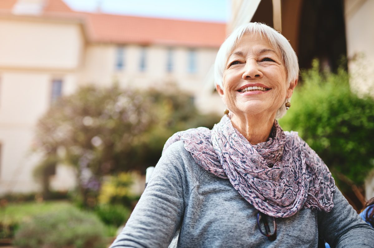 Smiling older woman with white hair enjoying time outdoors